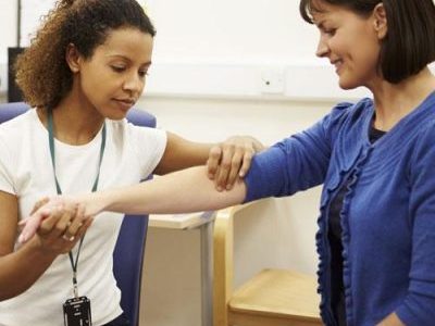 Female physio therapist is inspecting a female patient's arm